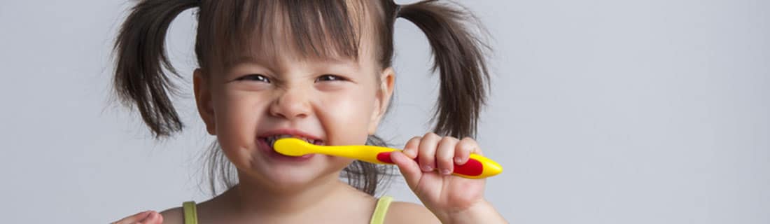 child brushing teeth smiling pigtails